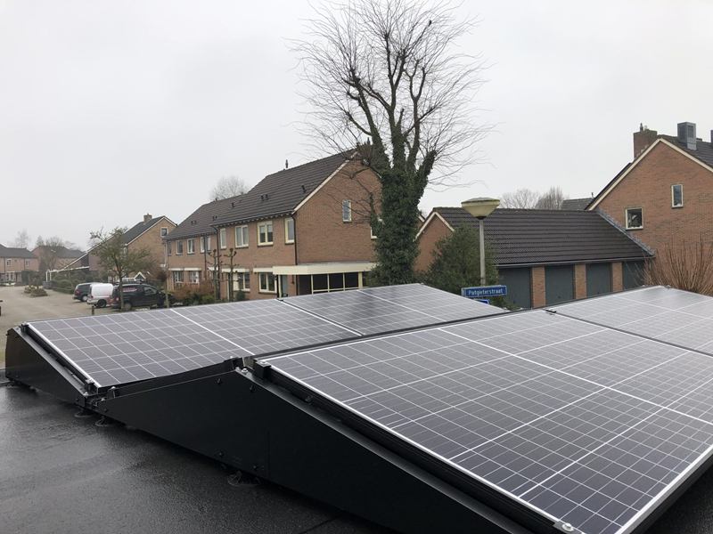 Zonnepanelen op een plat dak in een woonwijk